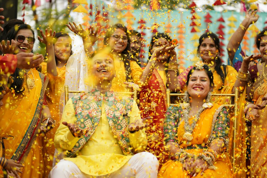 Haldi ceremony celebration with bride and groom surrounded by family and friends in yellow attire
